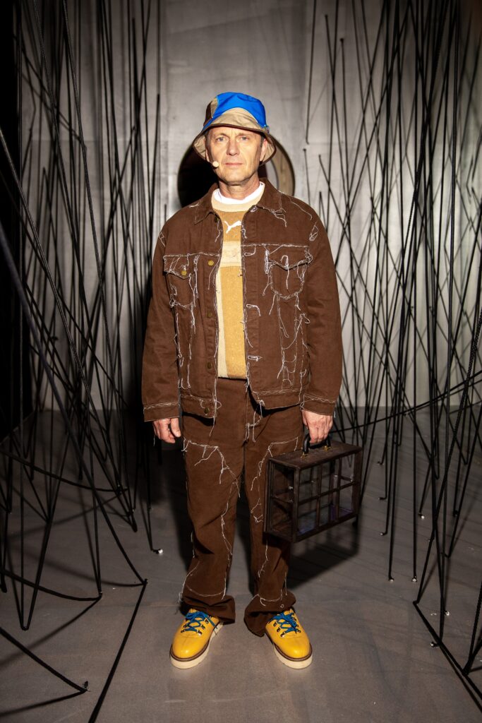 A relaxed brown denim jacket with long sleeves and collared design paired with matching pants.