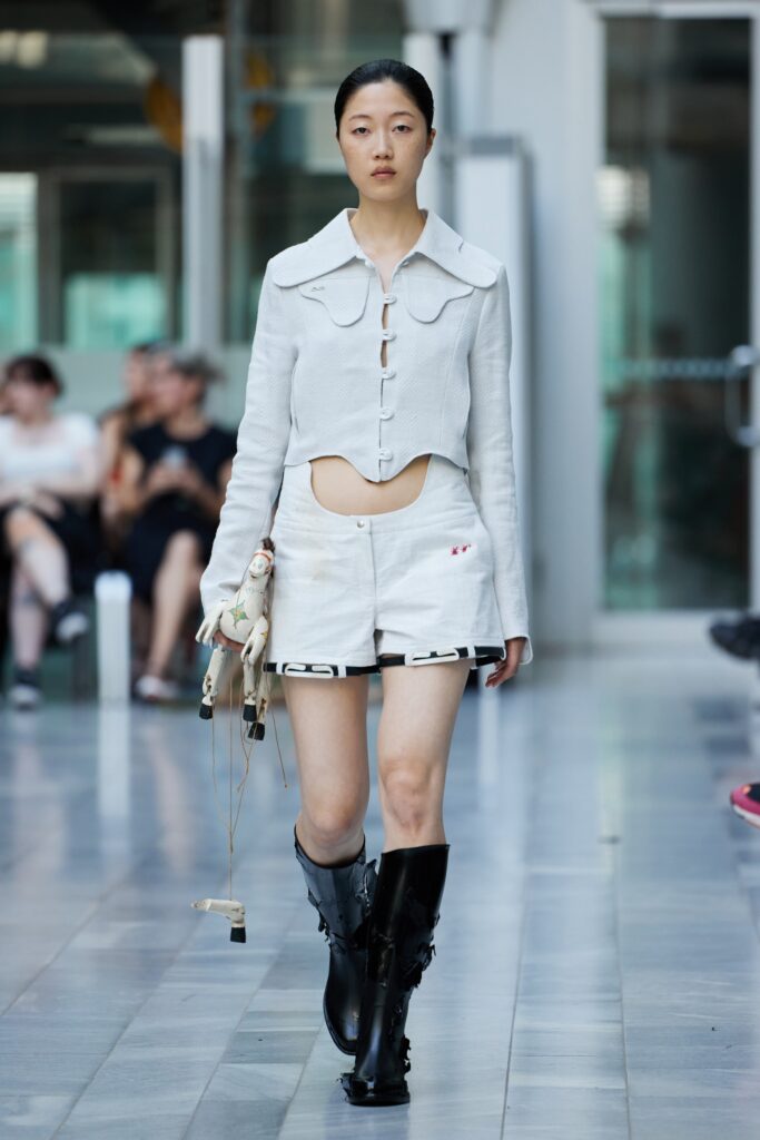 A white cotton shirt with a cutout design paired with stylish shorts for a modern look.