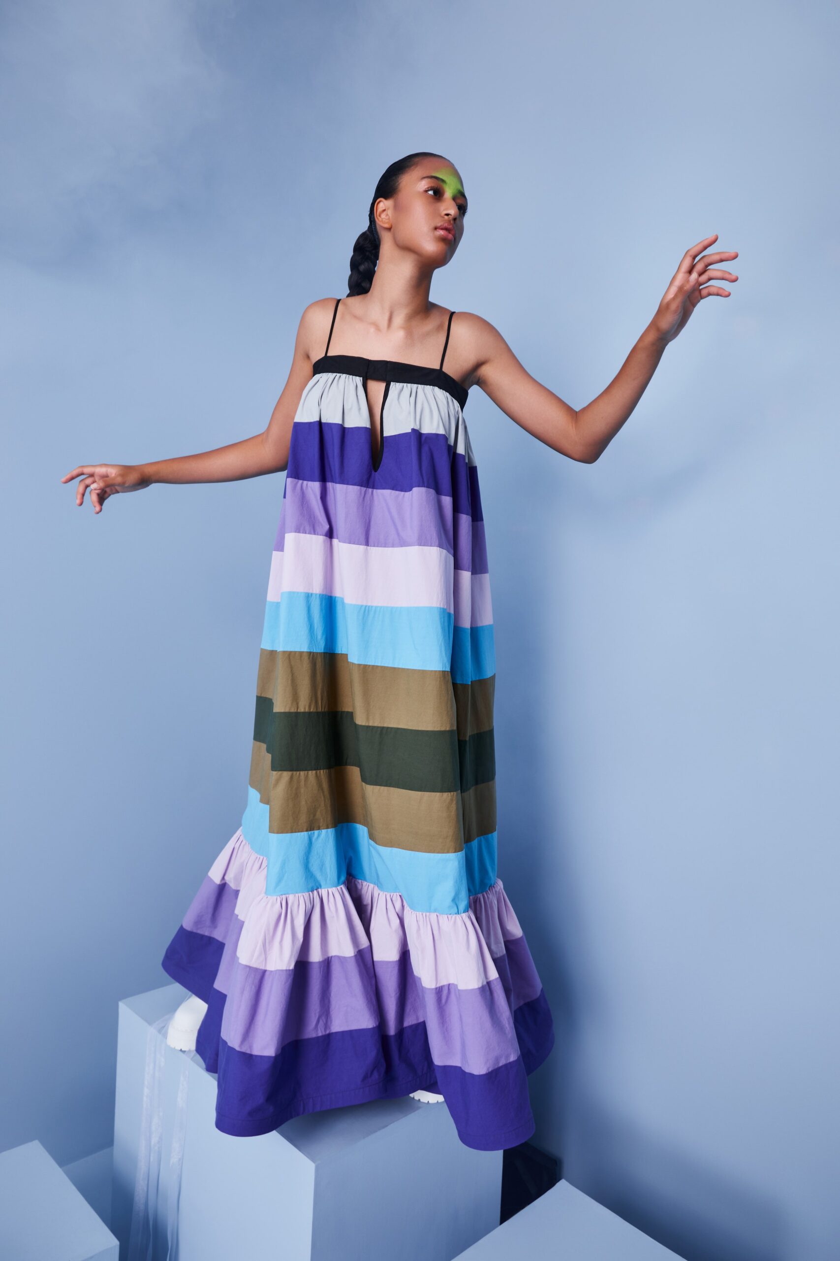 This relaxed dress features a vibrant array of colors, showcasing a playful tiered design that adds depth and movement. The sleeveless silhouette and V-neckline enhance its breezy appeal, making it a striking choice for warm days.