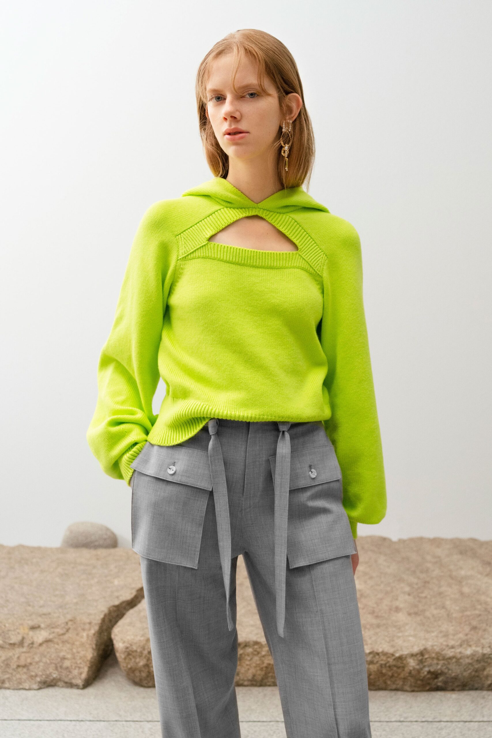 green cutout sweater and gray cargo pants