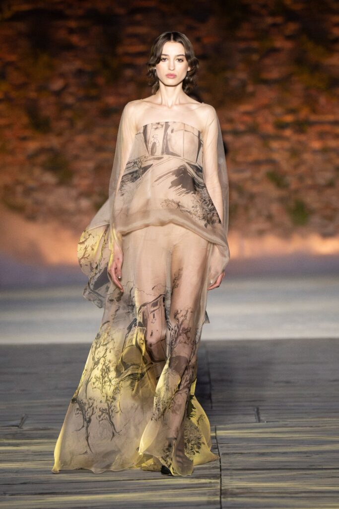 A relaxed beige silk strapless gown with layered detailing and artistic prints.