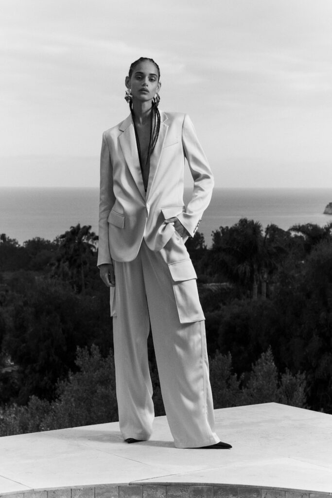 A relaxed white blazer paired with wide-leg pants, featuring a long-sleeve and collared design.