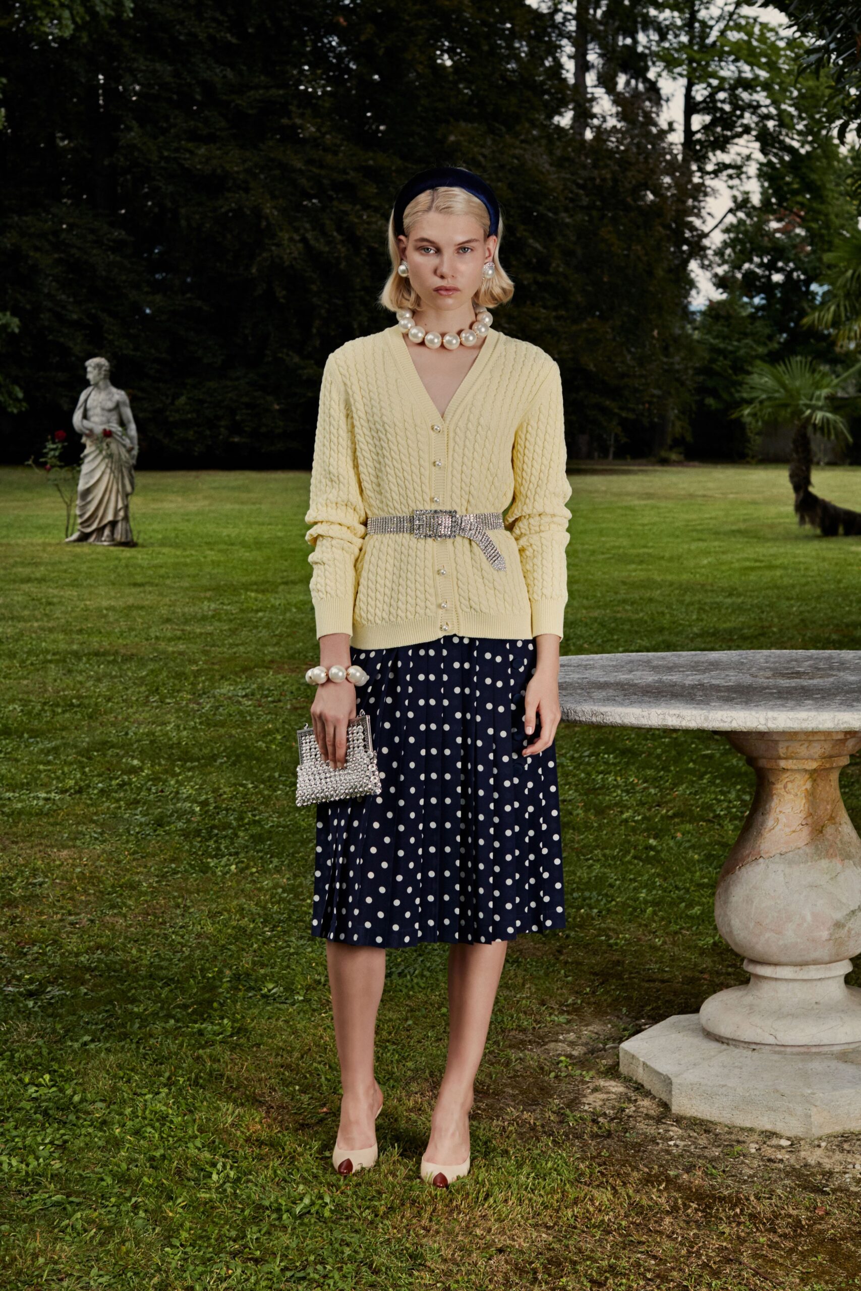 yellow knitted cardigan and navy polka-dot skirt