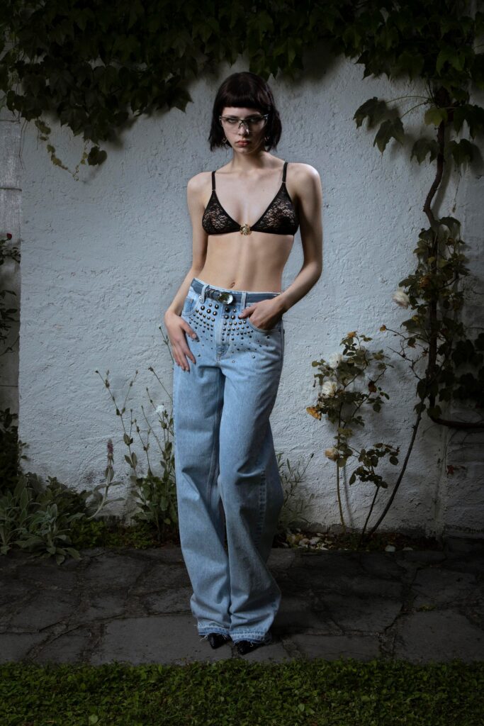 A relaxed black sleeveless top paired with high-waisted wide-leg blue jeans.