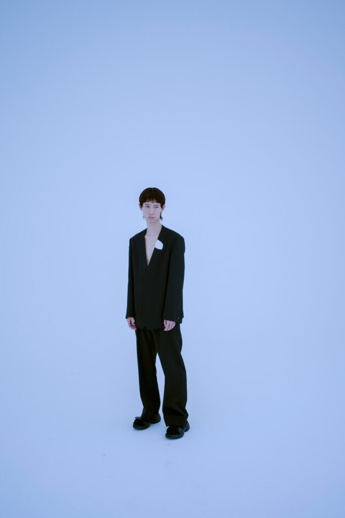 A relaxed black blazer with long sleeves and a V-neck, paired with straight-leg pants.
