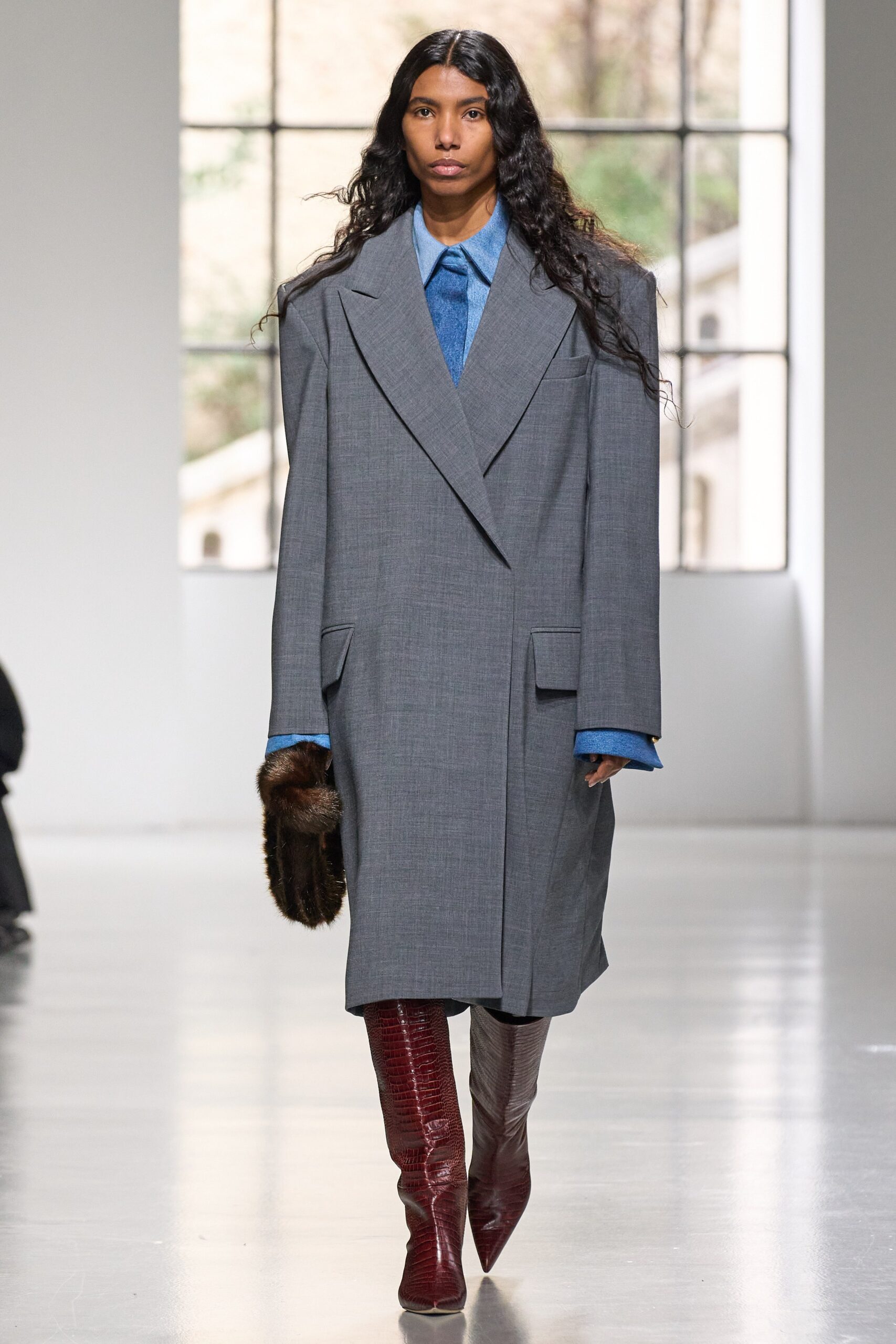 An oversized gray wool coat with long sleeves and a collared design, featuring button details.