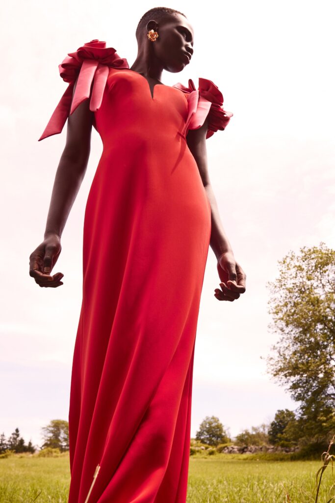 A fitted red silk dress with a V-neckline and ruffled sleeves.
