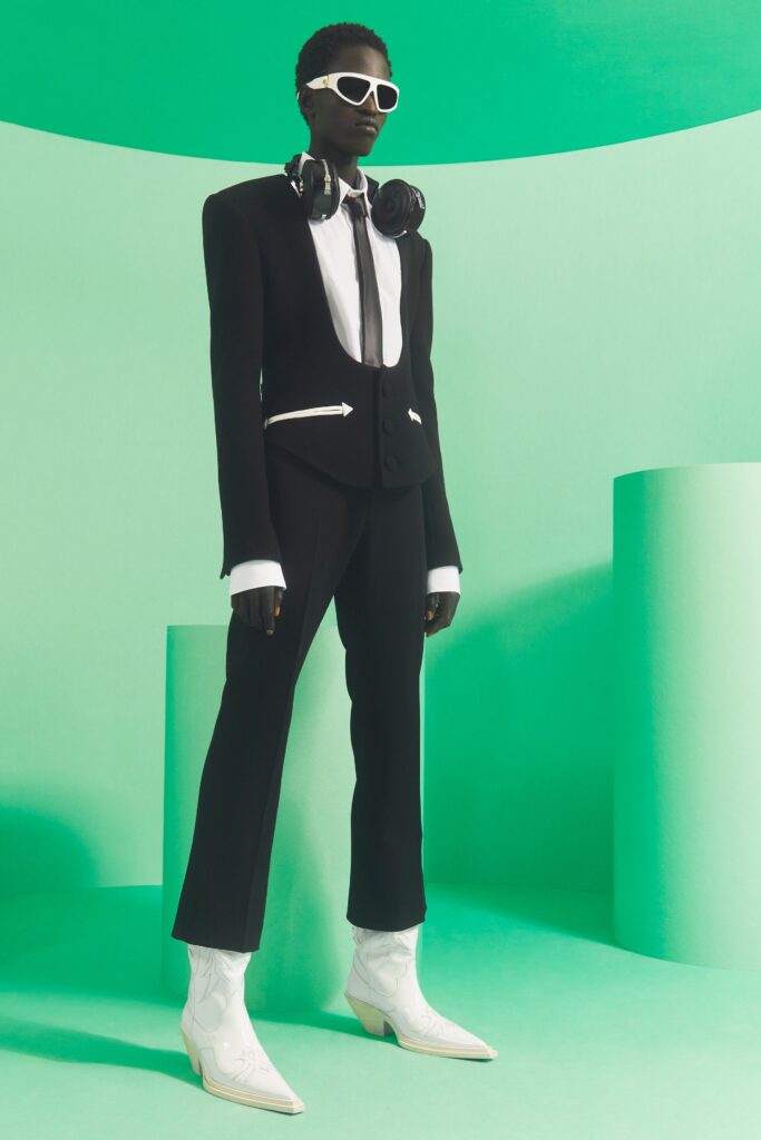 A tailored black and white suit with long sleeves and unique design elements.