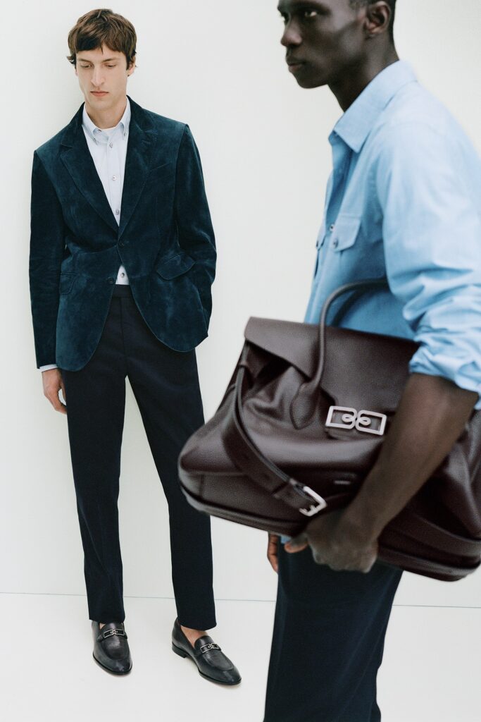 A tailored blue jacket with long sleeves paired with black tailored pants.