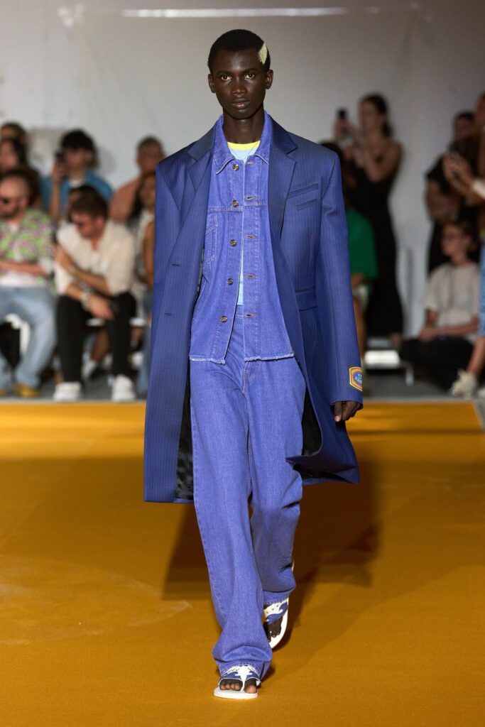 A relaxed blue denim jacket with long sleeves and collared design paired with matching pants.