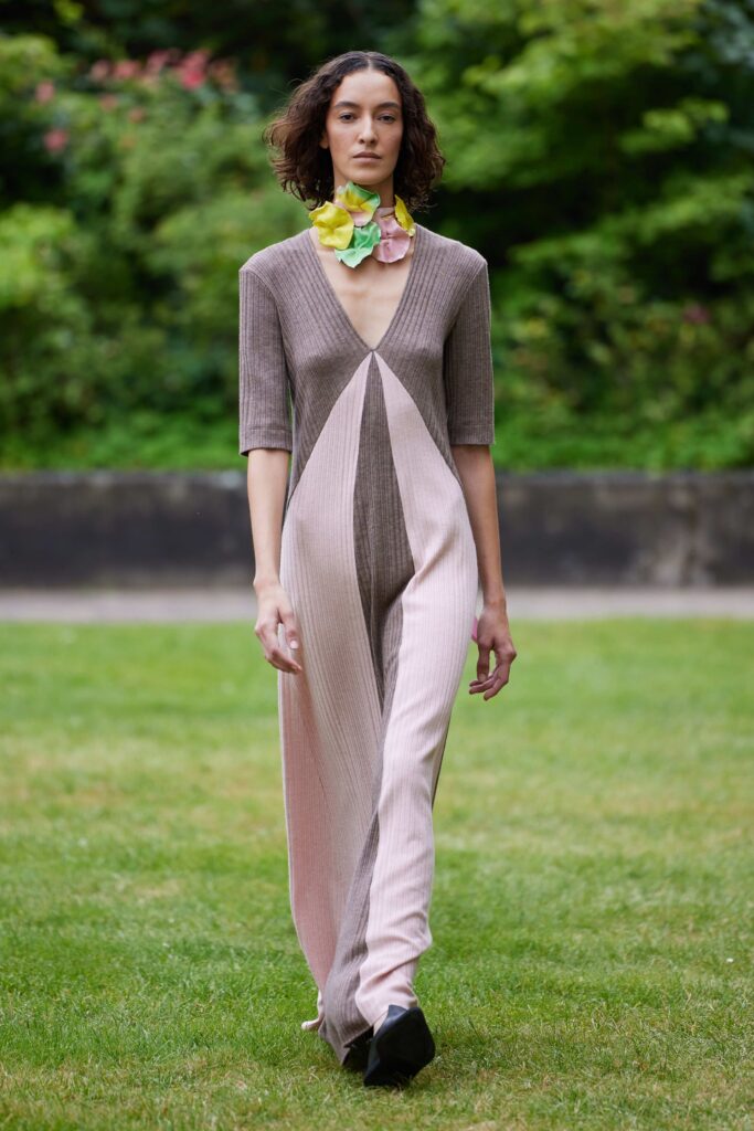 A fitted jumpsuit in brown and pink with a v-neckline and short sleeves.