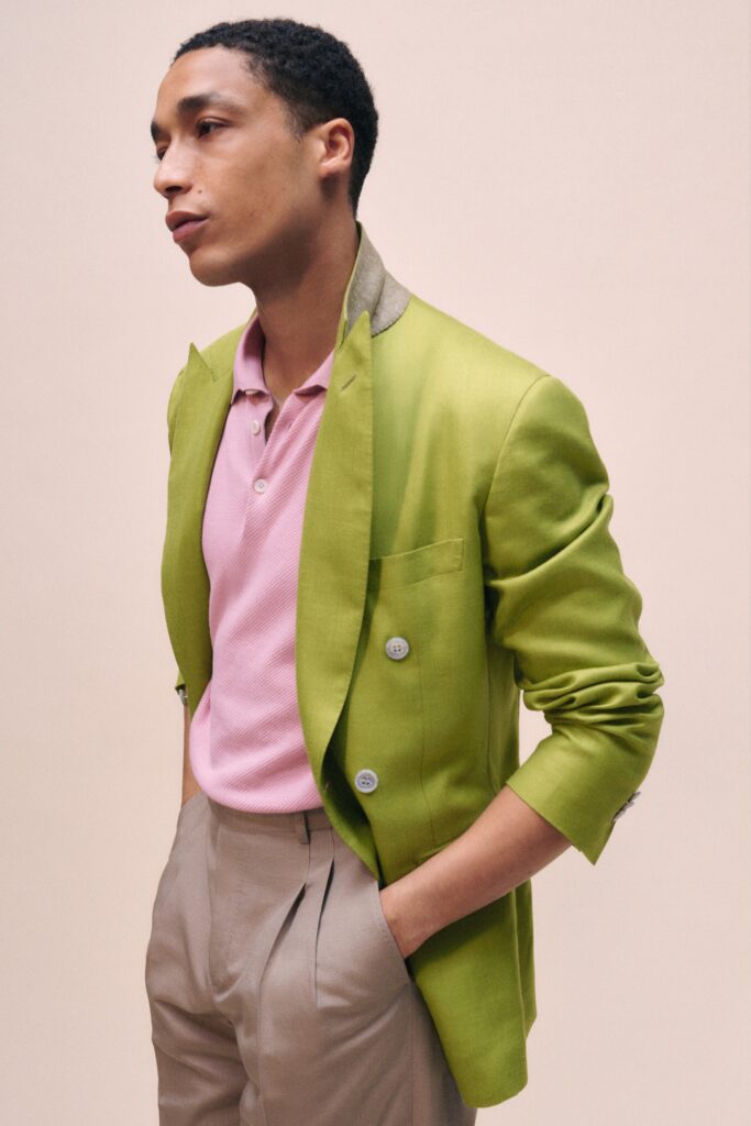A tailored green blazer paired with a collared pink shirt, featuring buttoned details.