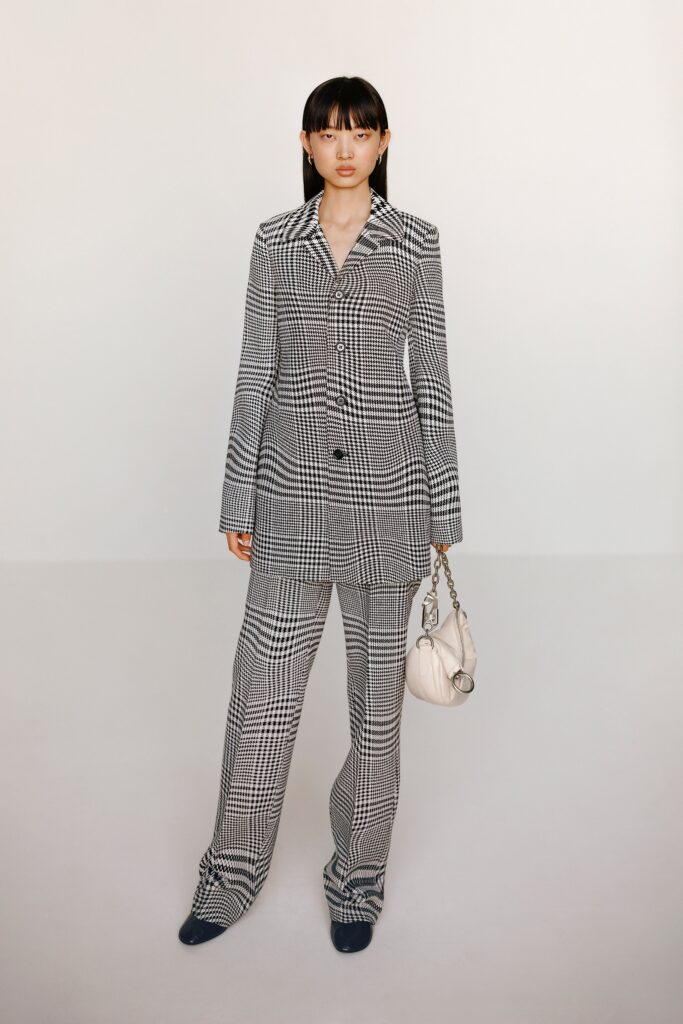 A tailored black and white checked suit with long sleeves and a collared design.