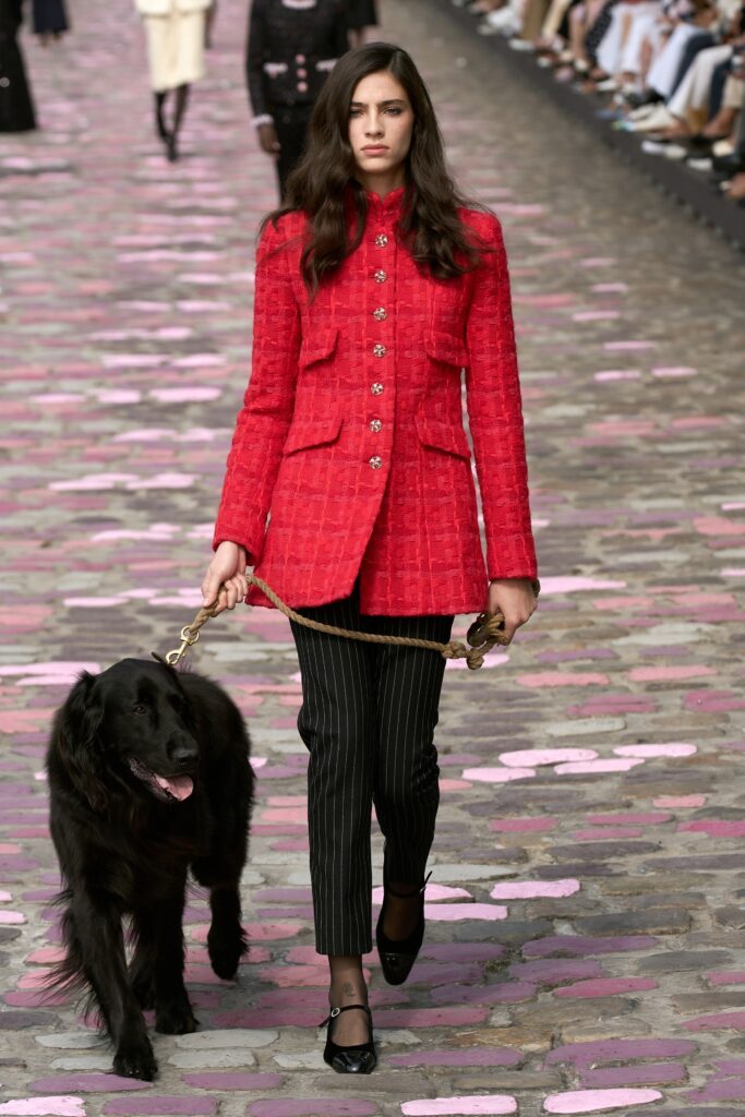 A fitted red jacket with a collared neckline paired with black striped pants.