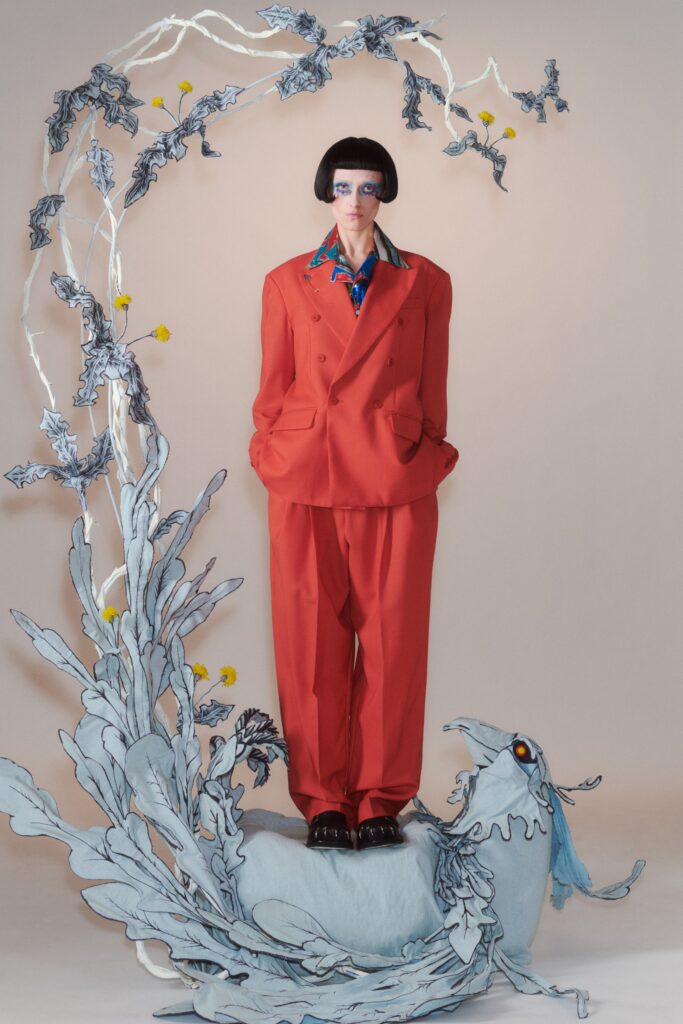 A tailored red suit with long sleeves and a collared shirt, featuring buttoned details.
