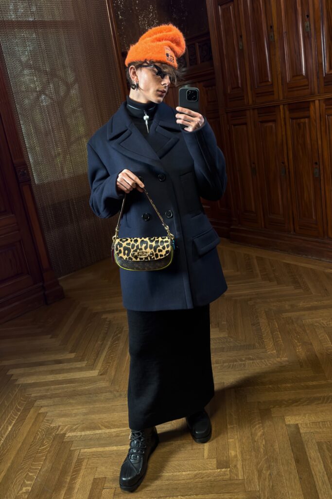 A fitted navy wool coat paired with a black straight-leg skirt, showcasing a sophisticated silhouette.
