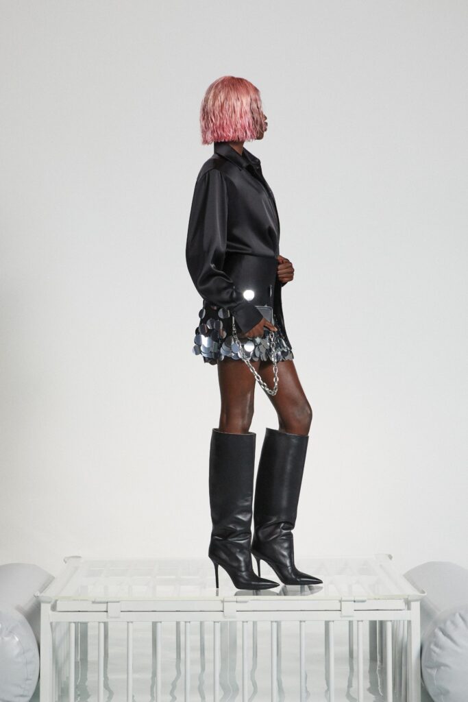 A fitted black silk dress with long sleeves, a collared neckline, and an asymmetric design.