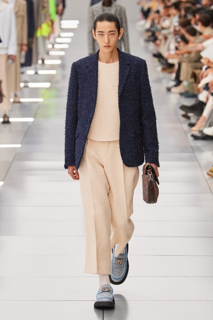A relaxed navy blazer paired with beige straight-leg pants for a stylish look.