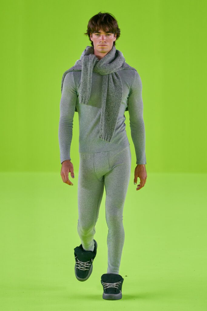 A fitted gray cotton jumpsuit with a hood and zippered detail.