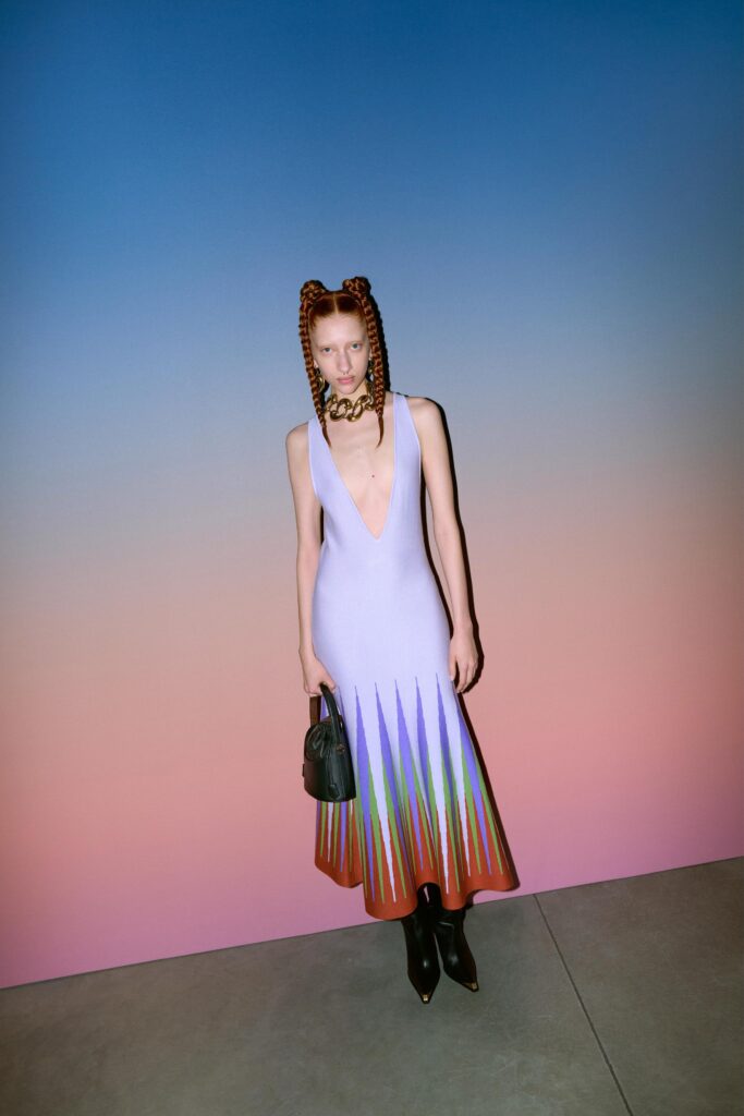 A fitted sleeveless purple dress with a V-neckline and flared silhouette featuring multicolor detailing.