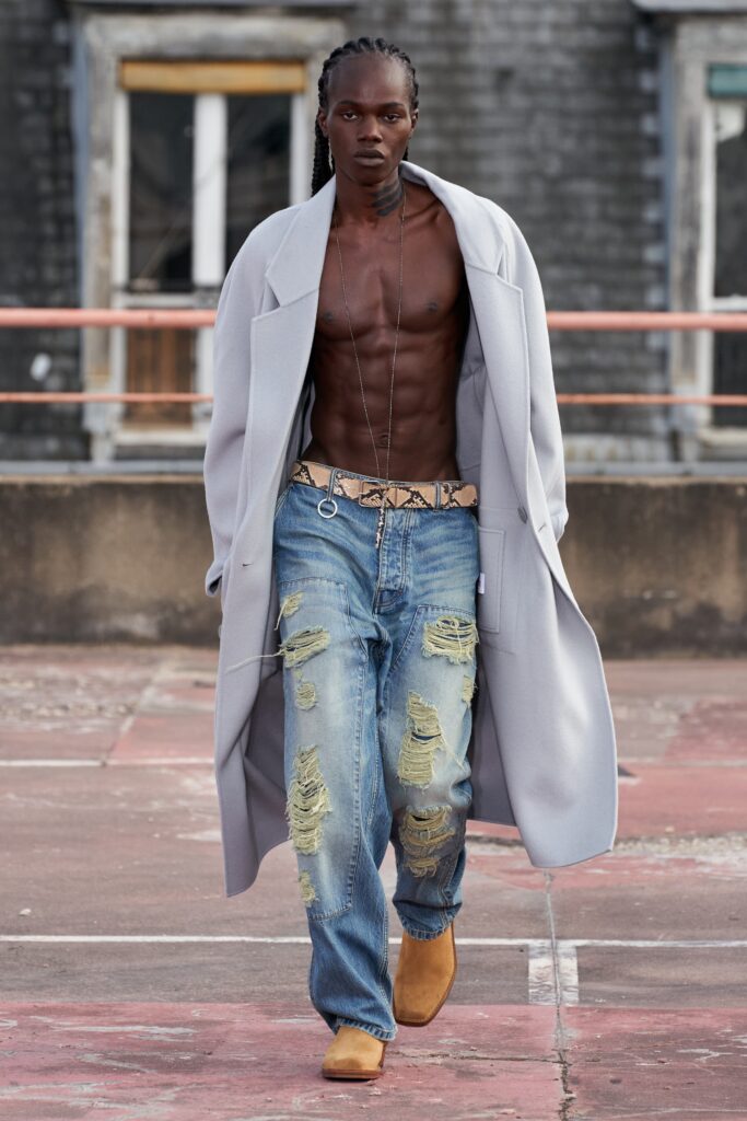 A relaxed gray coat paired with distressed blue jeans, creating a stylish urban look.