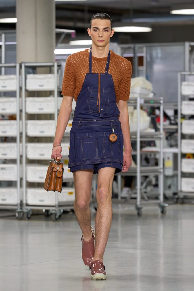 A fitted blue denim overall paired with a brown short-sleeve top featuring a collared design.