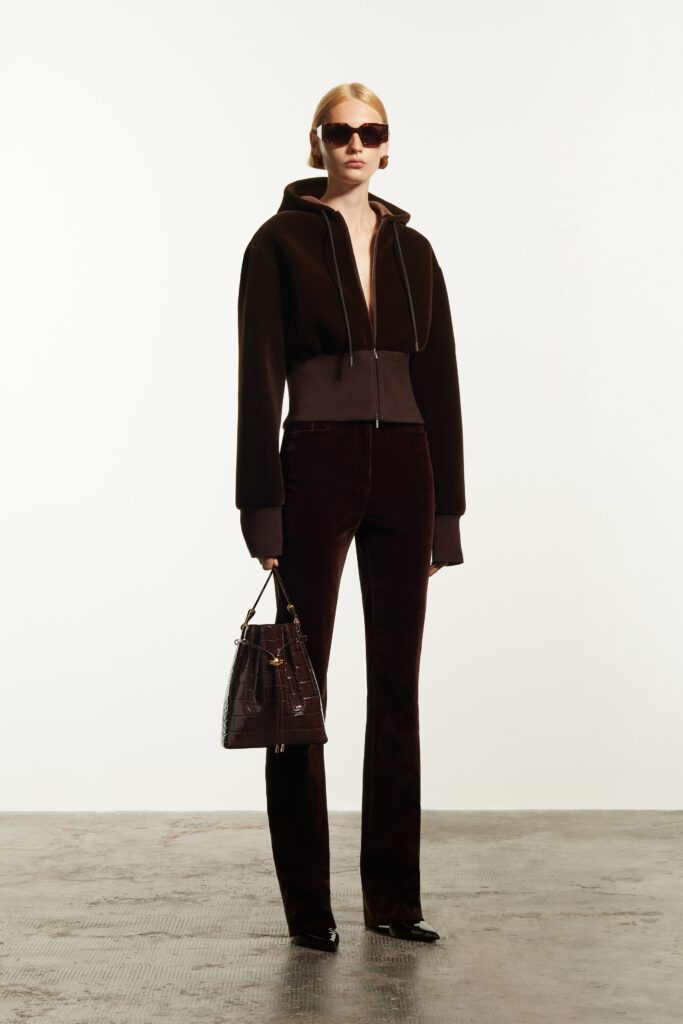 A fitted brown velvet jacket with a zippered front and straight-leg pants.