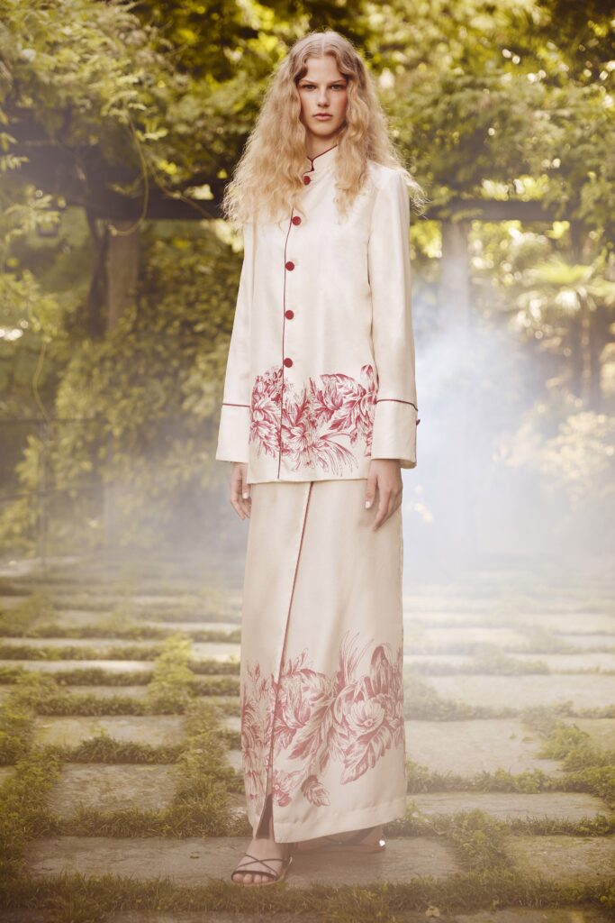 A fitted beige silk dress with an embroidered design, paired with a matching long-sleeve jacket.