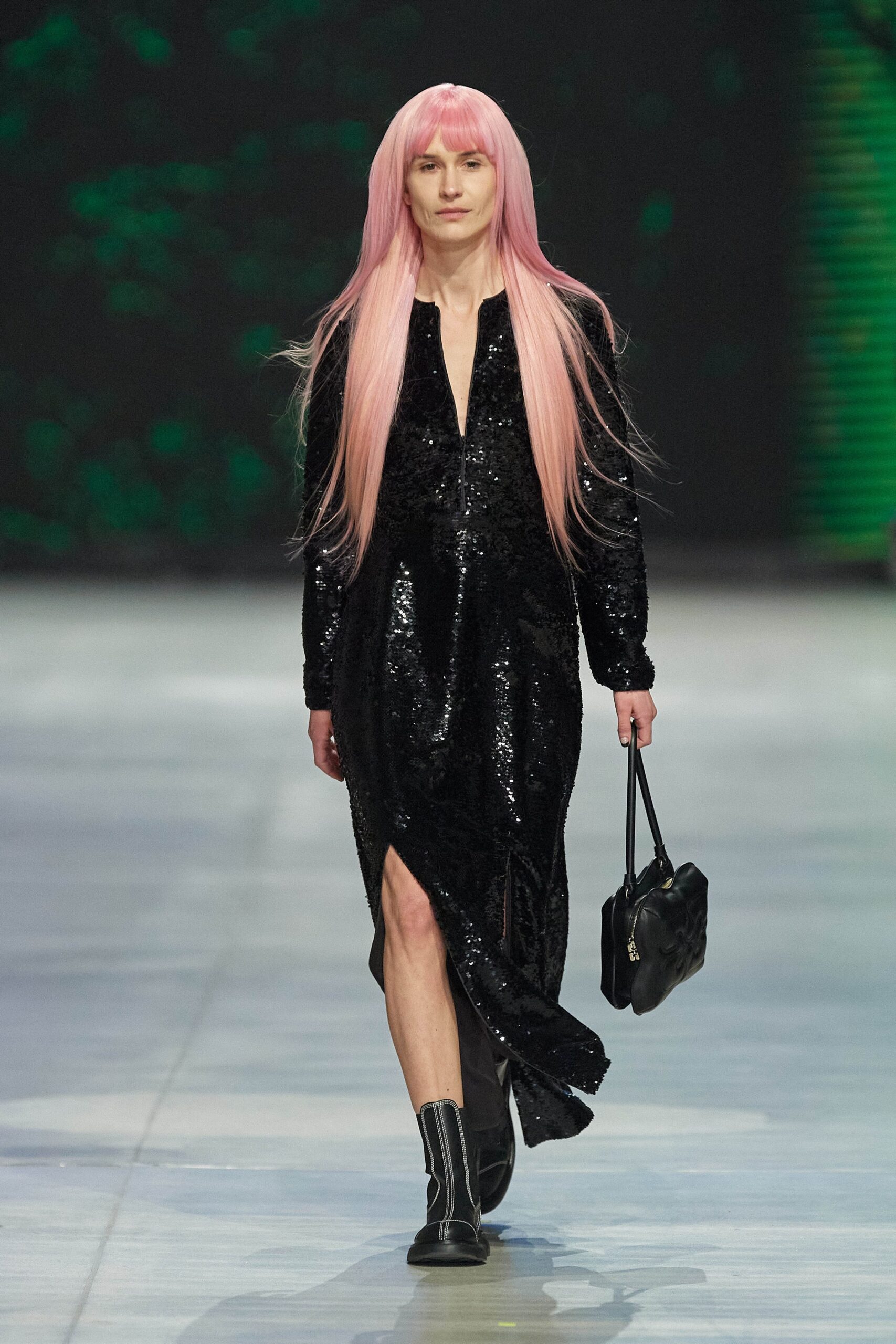 A fitted black sequin dress with long sleeves, a V-neckline, and a stylish slit.
