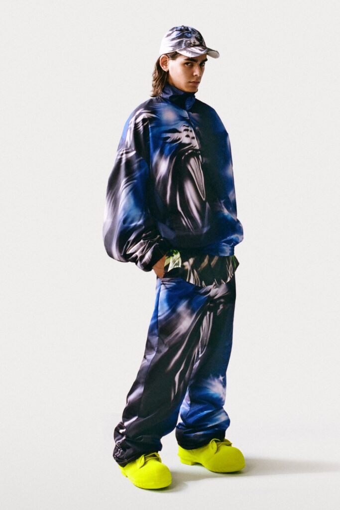 An oversized blue printed sweater paired with matching pants, featuring vibrant colors and a relaxed fit.