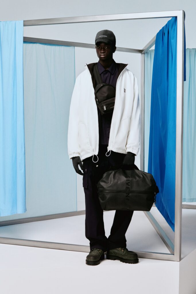 A relaxed white jacket with long sleeves and black pants, featuring a zippered detail.