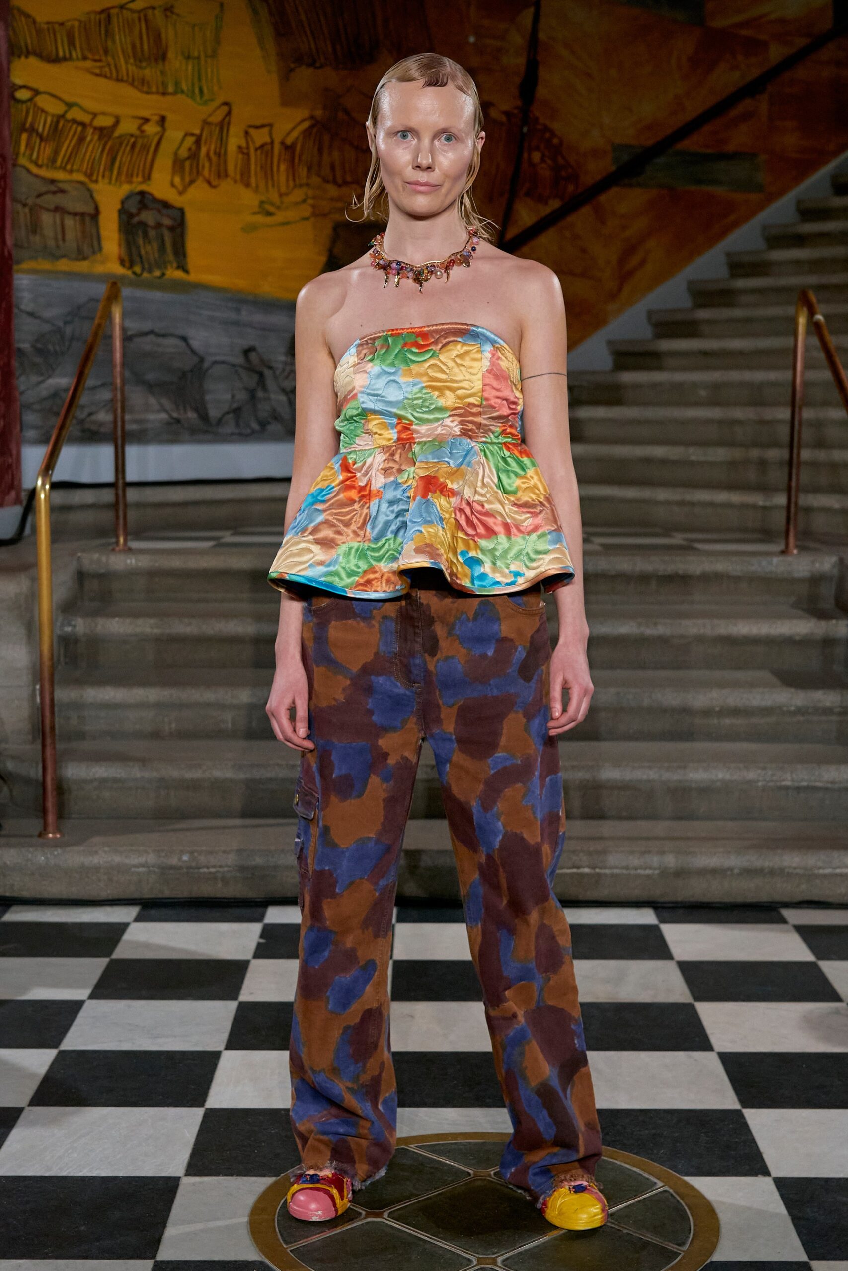 A relaxed fit multicolor sleeveless top paired with brown flared pants for a vibrant look.