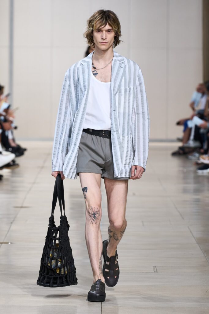A relaxed white striped short-sleeve shirt paired with gray shorts for a casual look.