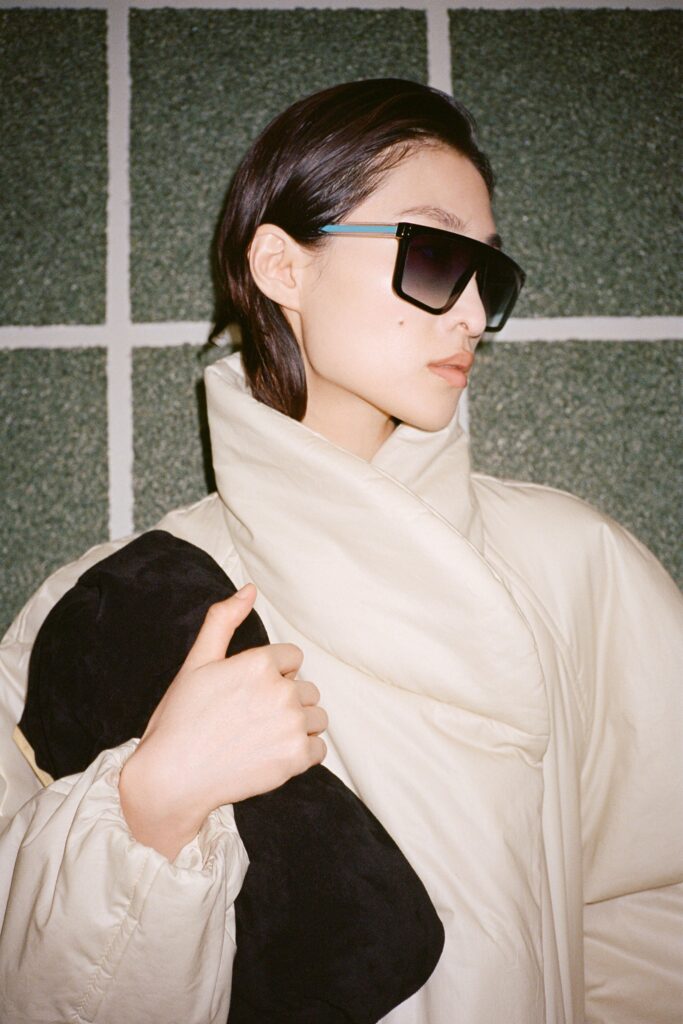 An oversized beige coat with long sleeves and a draped design.