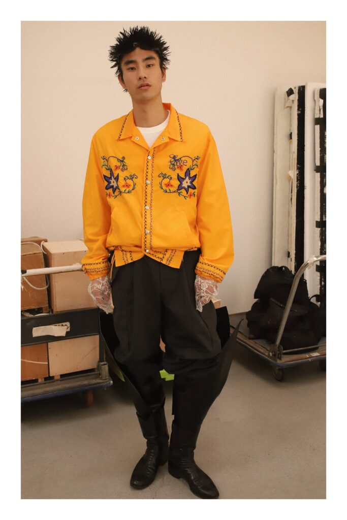 An oversized yellow jacket with embroidery paired with black pants for a bold fashion statement.
