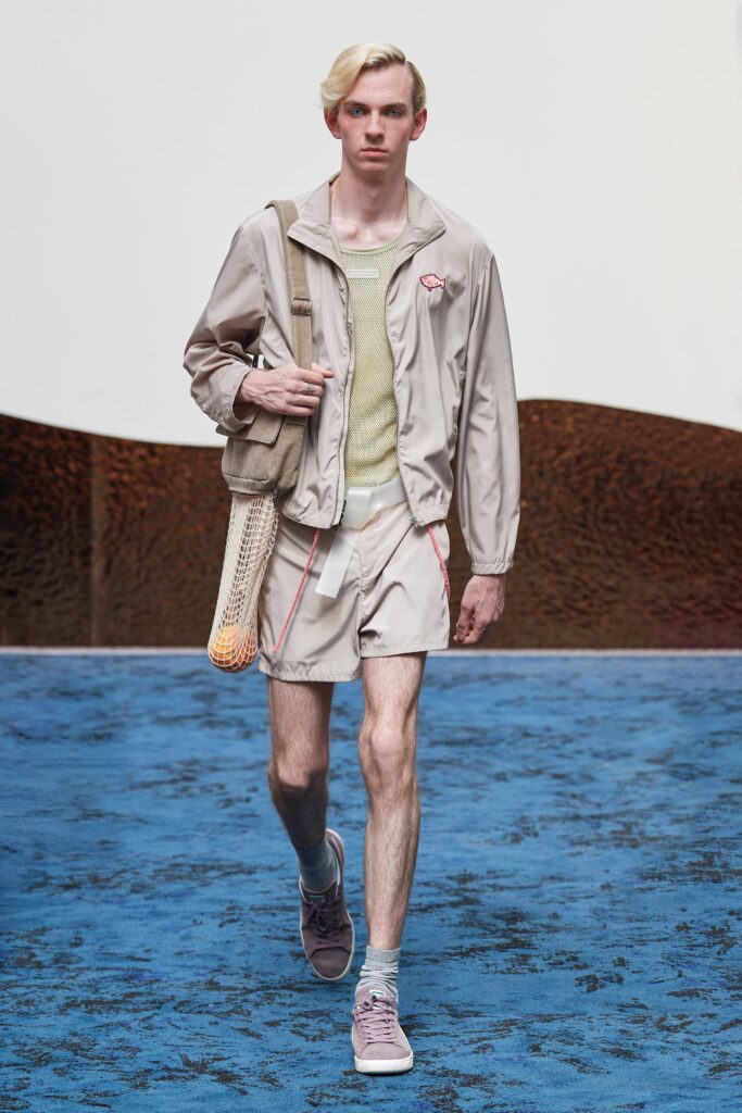 A relaxed beige cotton jacket with a collared neckline paired with green shorts.