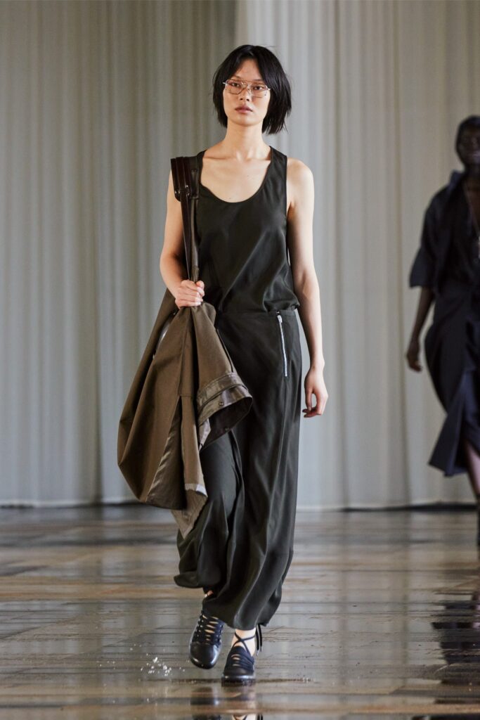 A relaxed green cotton sleeveless jumpsuit with a V-neckline and straight-leg design.