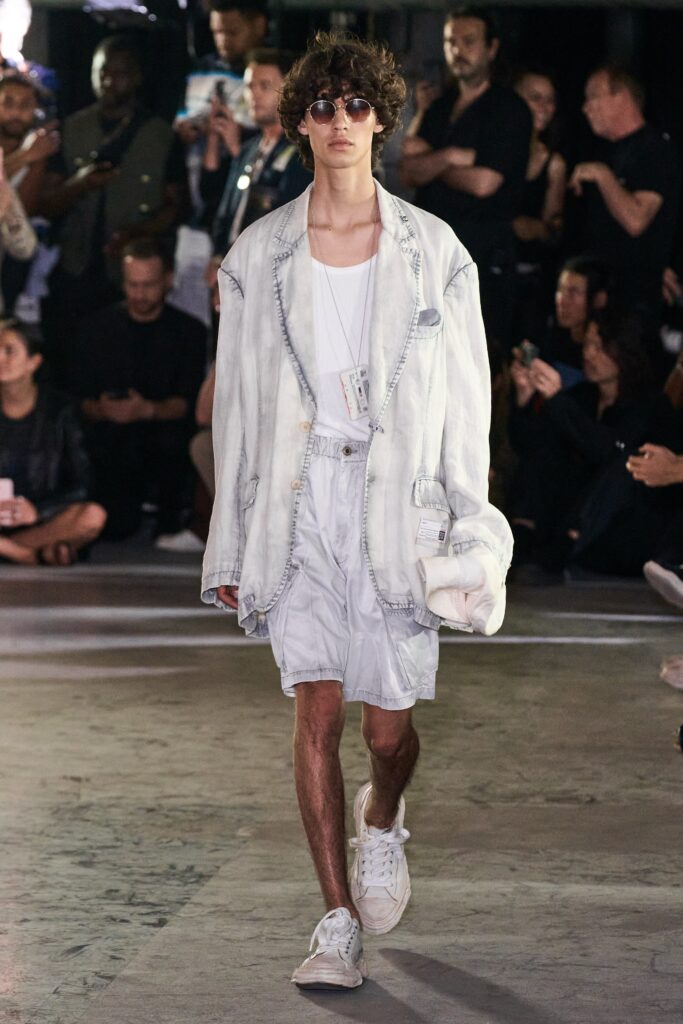 A relaxed white denim jacket paired with matching shorts, featuring a collared design and buttoned details.