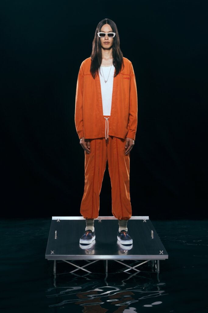 A relaxed fit orange cotton jacket with long sleeves and matching pants featuring a zippered detail.