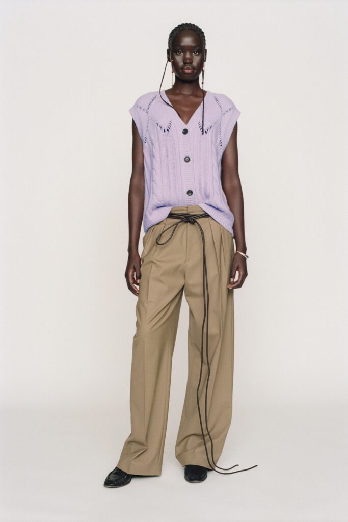 A relaxed purple cotton sleeveless top with a collared design paired with wide-leg beige pants.
