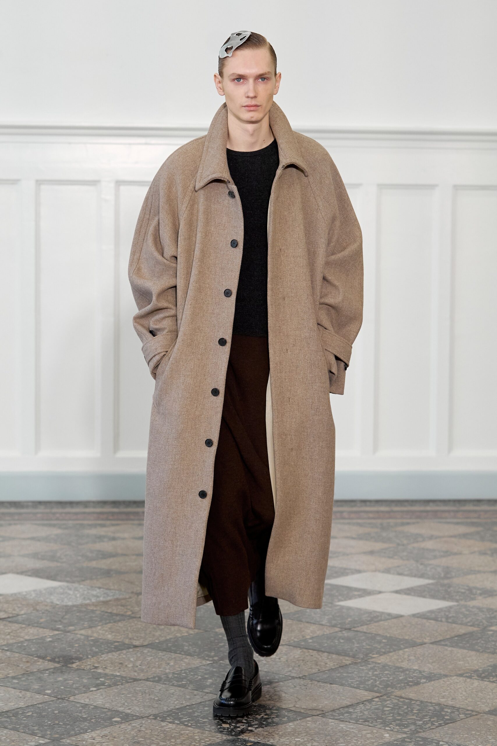 An oversized beige wool coat with a collared neckline and buttoned front.