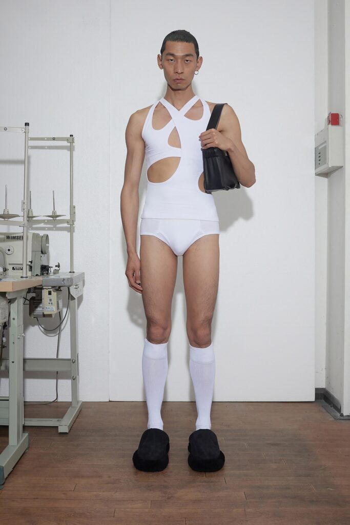 A fitted white bodysuit with cutouts, paired with matching shorts for a contemporary look.