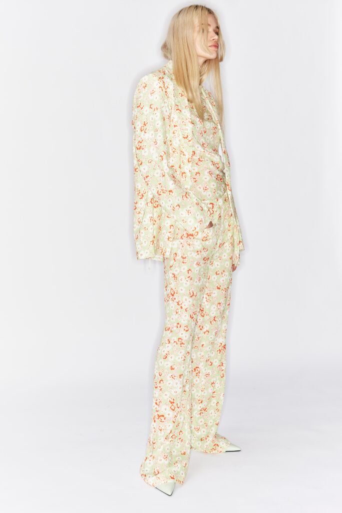A tailored cream suit with a floral pattern and long sleeves, perfect for a chic look.