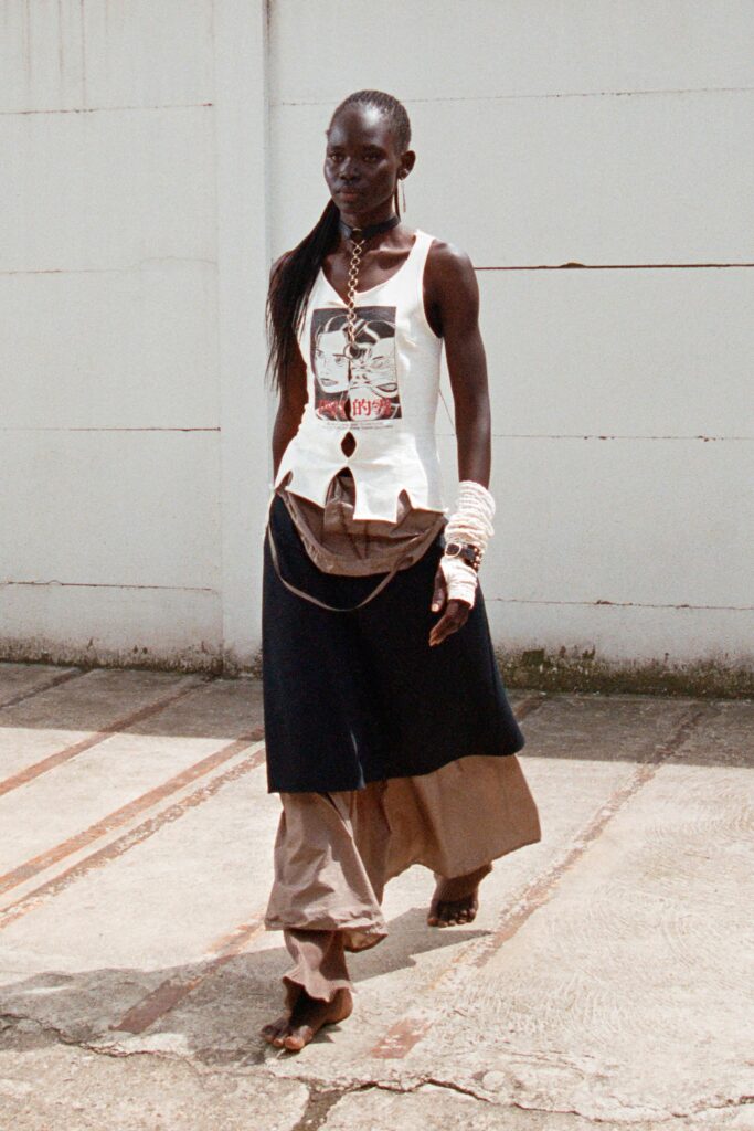 A relaxed sleeveless white top with a collared design paired with a layered navy and beige skirt.