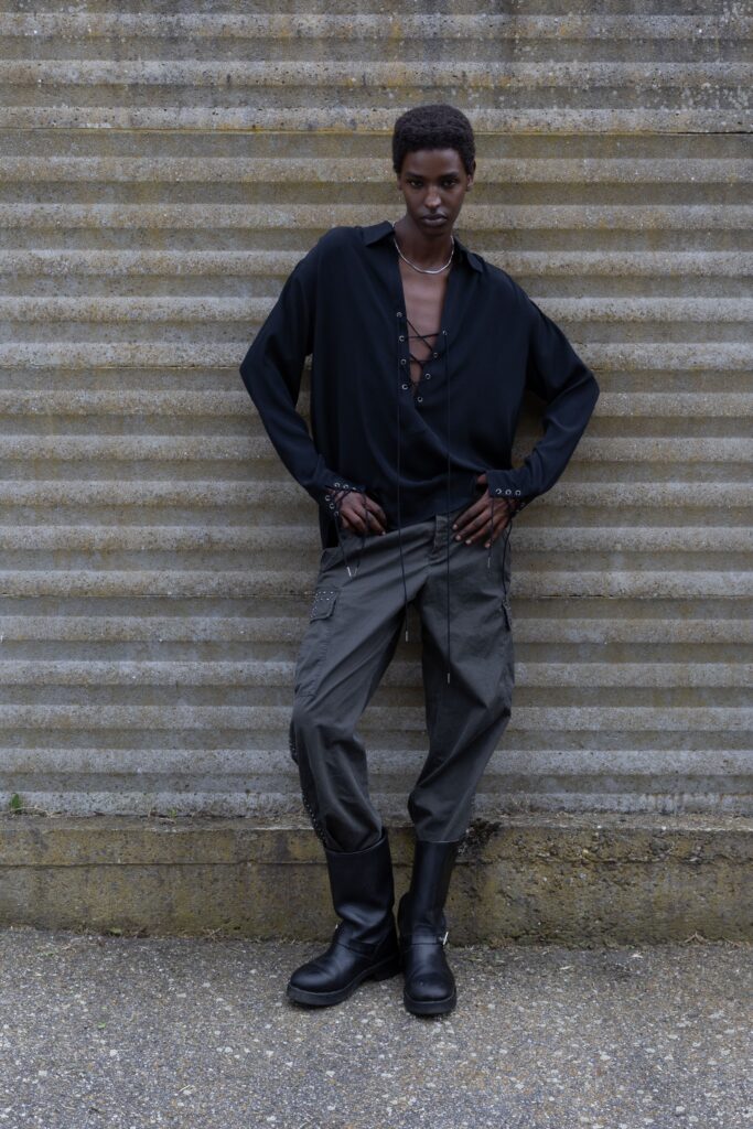A relaxed black long-sleeve shirt with a collared neckline paired with gray relaxed-fit pants.