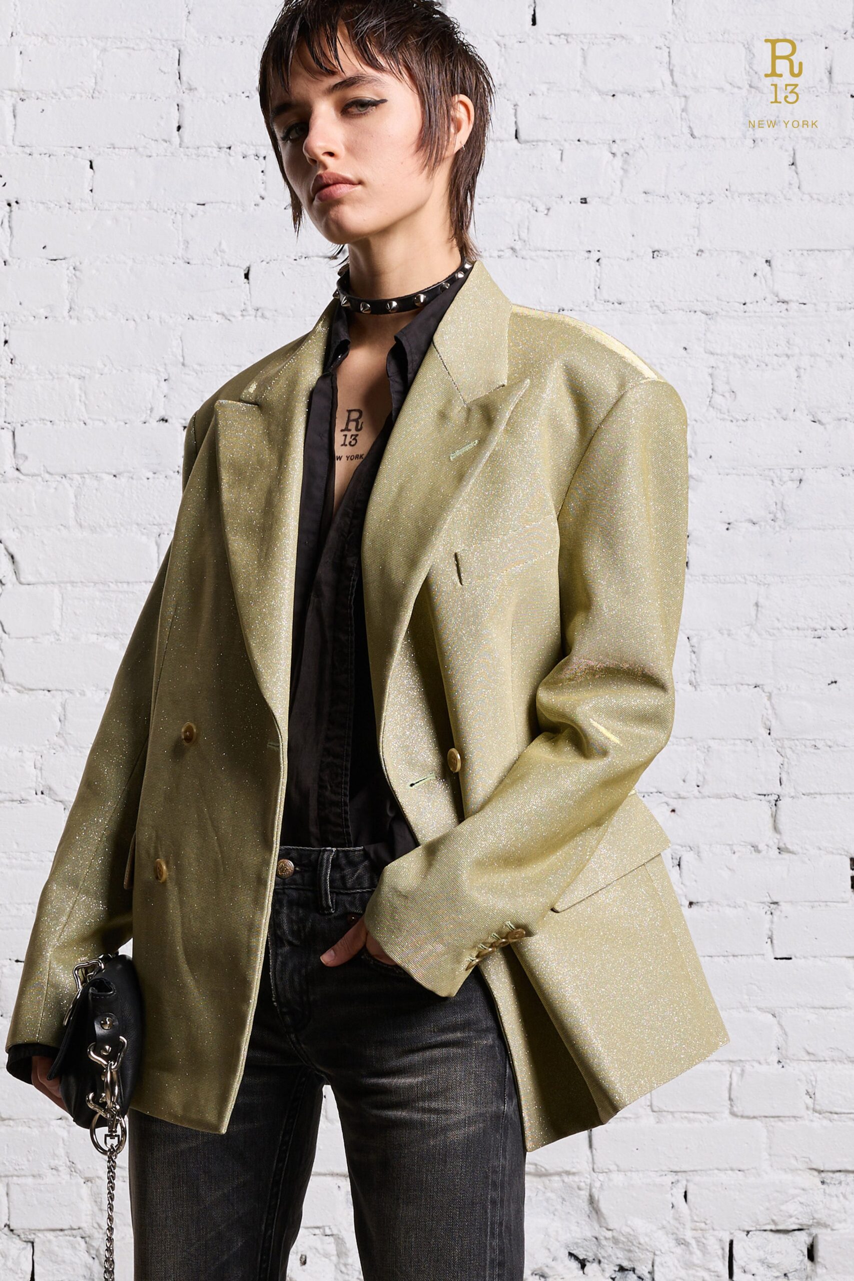 An oversized gold silk blazer with long sleeves and buttoned details paired with stylish pants.