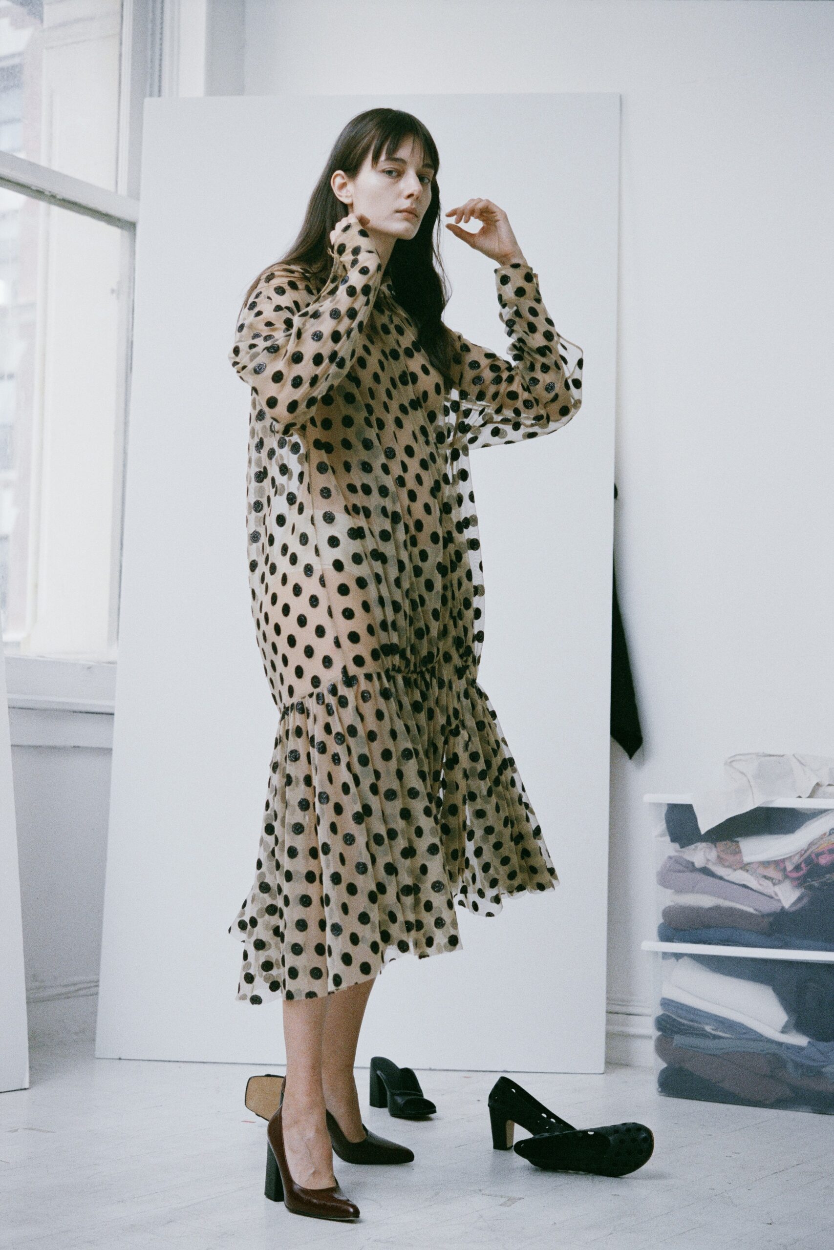 A relaxed beige sheer dress with long sleeves, a high neckline, and a tiered design featuring polka dots.