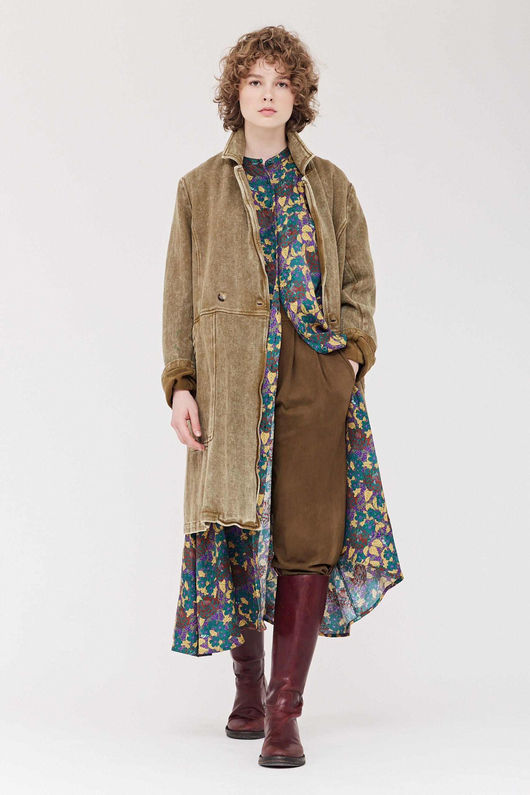 A relaxed brown coat over a floral long-sleeve dress with layered design elements.