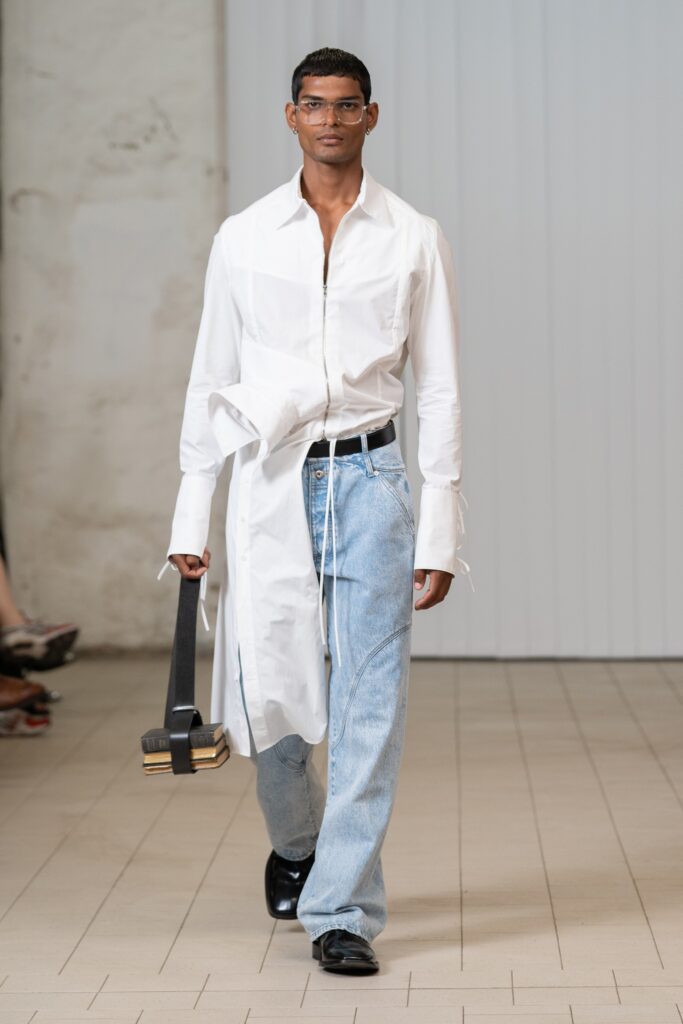 An oversized white buttoned shirt paired with blue denim jeans for a casual look.