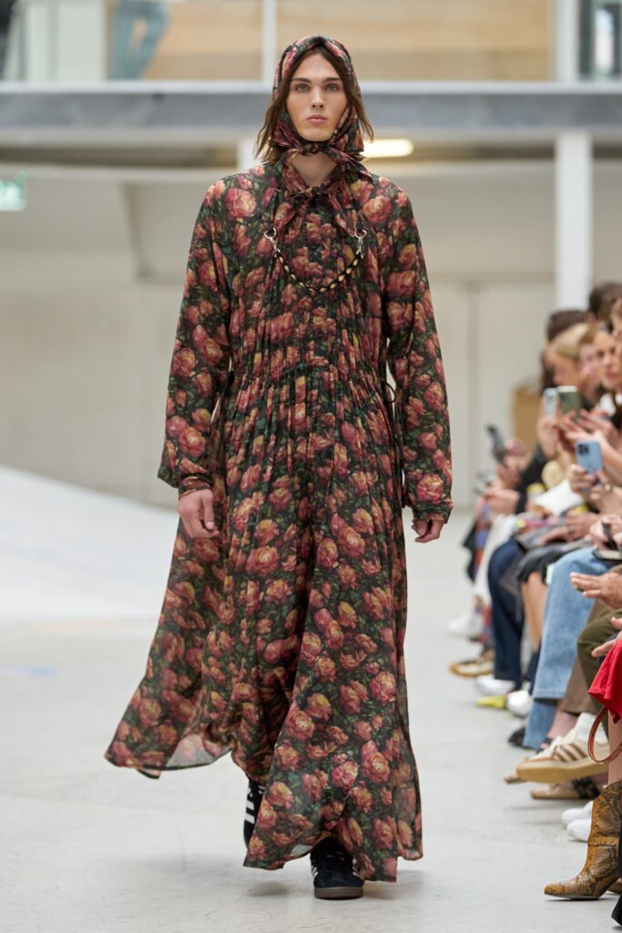 A relaxed multicolor floral dress with long sleeves and a high neckline featuring pleated details.